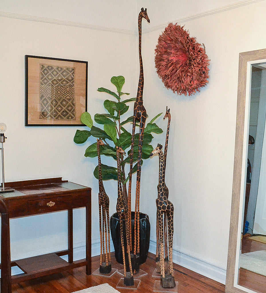 Five carved giraffes in an entryway