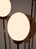 Three Egg Ostrich Egg Lamp, a floor lamp made from ostrich eggs and painted metal in South Africa, shown lit