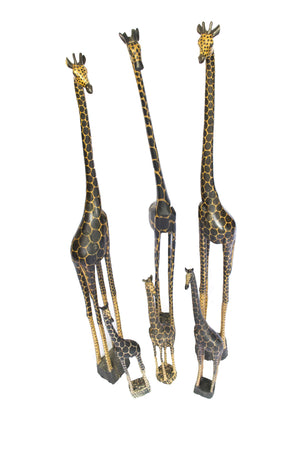 High angle view of six Giraffe carvings with black patches painted over pale teak wood