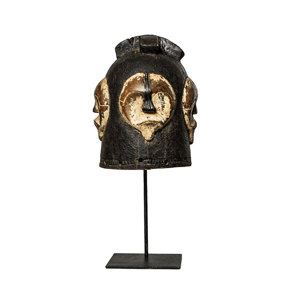 Helmet Mask, a Fang helmet mask carved from wood in Cameroon, with four white faces around a dark head, on a metal stand