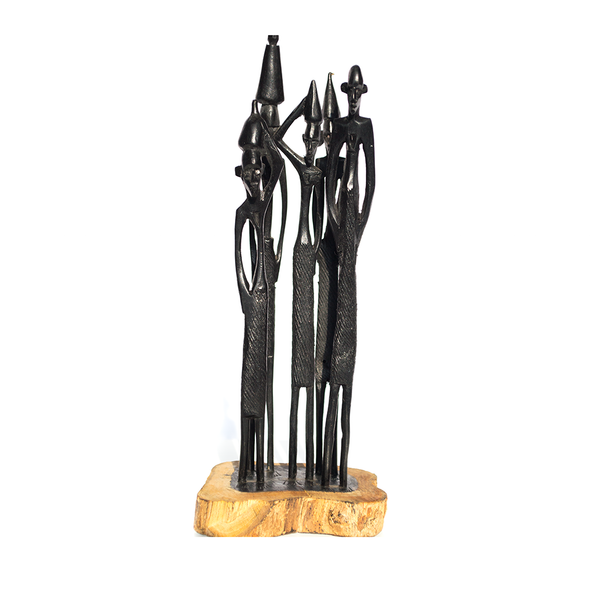 Masaai People, a group of slender figures on a pale wood base, carved from ebony wood in Kenya by the artist Nelson