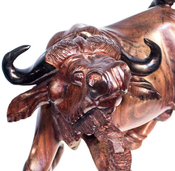 Buffalo, a cape buffalo with lowered head and black horns, carved from ebony wood in Kenya